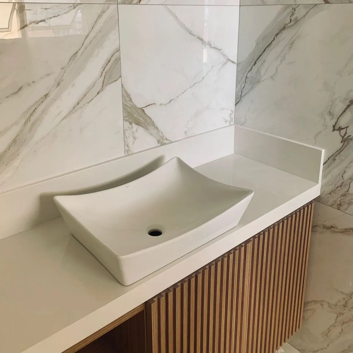 Lavabo com bancada em pedra com veios